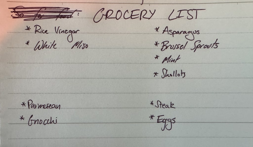 A handwritten grocery list is visible with items listed under various categories. The list appears to be organized with items like Rice Vinegar, White Miso, Asparagus, Brussel Sprouts, Mint, Shallot, Parmesan, Gnocchi, Steak, and Eggs.