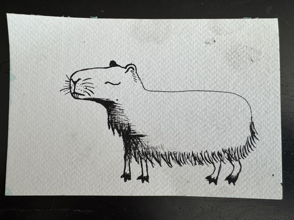 A drawing of a capybara, created with a black ink pen on a textured paper napkin. The style is simplified and cartoonish, with sketchy and expressive lines. The capybara is depicted without much detail but is recognizable by its distinct shape and features like its rounded head, small ears, and the characteristic muzzle of the species. There are hatched lines to indicate shading on its underbelly and legs, giving the creature volume. It's facing to the right and has a closed, content expression.